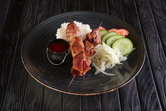 Shashlyk on skewer with rice and fresh tomato
