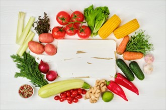 Top view of assortment of fresh eco vegetables on white wooden background. World food day concept