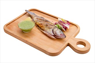 Whole fried fish on wooden board