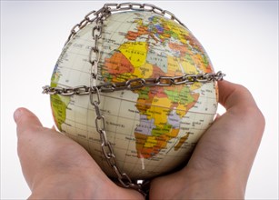 Hand holding a globe in chains