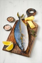 Whole fresh chinook on wooden cutting board with spice