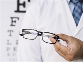 Male doctor holding pair eyeglasses his hands. Resolution and high quality beautiful photo