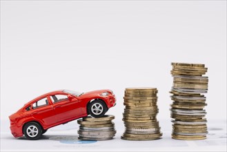 Toy car going up increasing stack coins against white background. Resolution and high quality beautiful photo