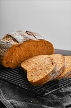 Closeup view of artisan whole grain tomato wheat bread cut on slices on wooden table