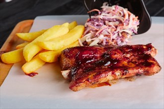 Rustic lunch. Grilled ribs with fried potato and red cabbage salad