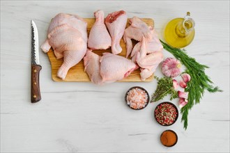 Overhead view of variety of fresh chicken meat on wooden cutting board with spice