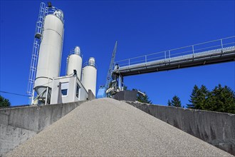 Steel silos and shovel crane with gravel hill and conveyor belt