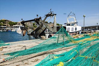 Fishing nets lying stretched out to dry for repair on quay at harbour pier