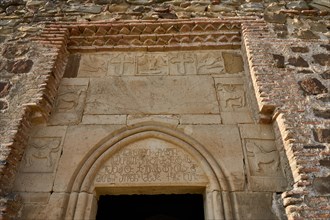 Entrance portal with old Georgian inscription and relief panels with animal motifs