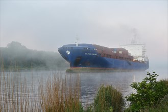 Container ship Delphis Finland sailing through the Kiel Canal in fog