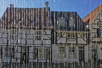 Half-timbered houses behind water from the weavers' well at Tuchmacherplatz