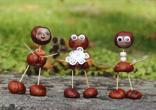 Three funny chestnut figures in the garden
