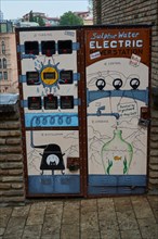 Electricity meters and cable distribution boxes decorated with graffiti on a street in the old town