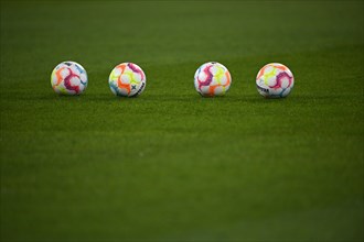 Four adidas Derbystar match balls lie on grass
