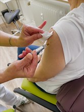 Woman gets influenza vaccination in doctor's surgery Influenza vaccination