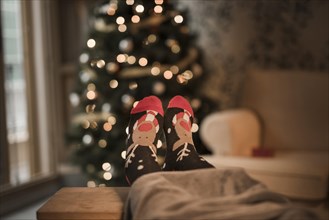Human legs funny socks near christmas tree