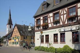 Half-timbered house Gasthaus zum Engel and steeple of St. Mark's Church with people