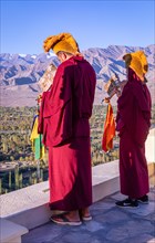 Monks blowing conches at Spituk Monastery