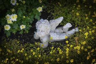 Grave with stone putto between flowers
