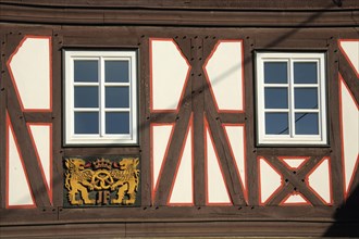 Wood carving with lion figures and pretzel on half-timbered house