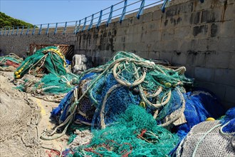 Fishing nets lying piled up up on harbour pier