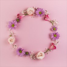 Blank circular frame made with flowers pink background