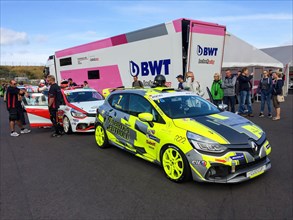 Race cars Renault Clio type race cars from Clio Cup racing series wait for clearance to enter race track in front of starting grid