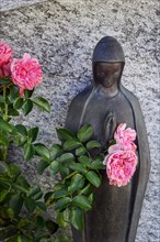 Gravestone with praying female figure with roses