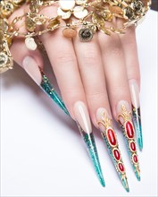 Long beautiful manicure on the fingers of turquoise and red. Nails design. Picture taken in the studio on a white background. Isolate object