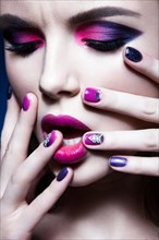 Beautiful girl with bright creative fashion makeup and colorful nail polish. Art beauty design. Photos shot in studio
