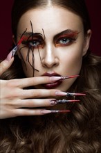 Portrait of woman in the image of spider with creative art makeup and long nails. Manicure design