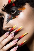 Beautiful girl in the image of the Phoenix bird with creative makeup and long nails. Manicure design. The beauty of the face. Photos shot in studio