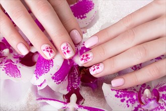 Shot beautiful manicure with flowers on female fingers. Nails design. Close-up. Picture taken in the studio on a white background