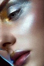 Beautiful girl with creative golden and silver glitter make-up. The beauty of the face. Photos shot in studio