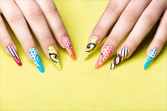Long beautiful manicure in pop-art style on female fingers. Nails design. Close-up