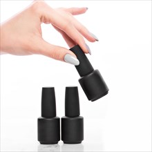 Black bottles of nail polish on a white background. Manicure design
