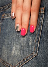 Bright neon manicure on female hands on the background of jeans. Nail design. Beauty hands