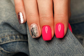 Bright neon manicure on female hands on the background of jeans. Nail design. Beauty hands