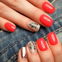 Bright neon manicure on female hands on the background of jeans. Nail design. Beauty hands