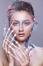 Beautiful girl in the image of a sweet fairy with art make-up and with long design nails. Creative manicure. Photo taken in the studio