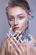 Beautiful girl in the image of a sweet fairy with art make-up and with long design nails. Creative manicure. Photo taken in the studio