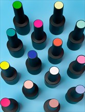Black bottles of nail polish on a blue background. Manicure design