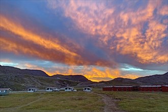 Dramatic sunset over small cabins at a campsite
