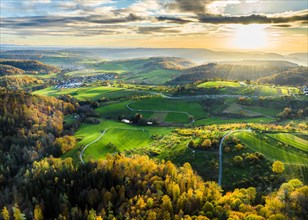Drone view of sundown over forest and rural landscape in autumn
