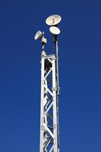 Transmission mast with directional radio antenna and antennas for mobile phone reception