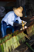 A woman in a straw hat preparing Sticky Rice