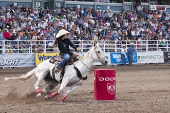 Cowgirl riding fast during barrel racing