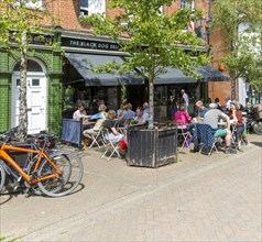 People sitting on street outside cafe