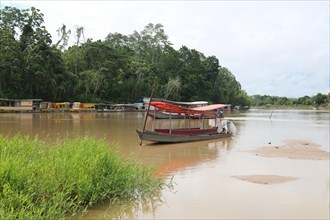 Fishing boats and transport boats on the Jordao River in the Amazon rainforest