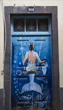 Colourfully painted door with mermaid on a swing